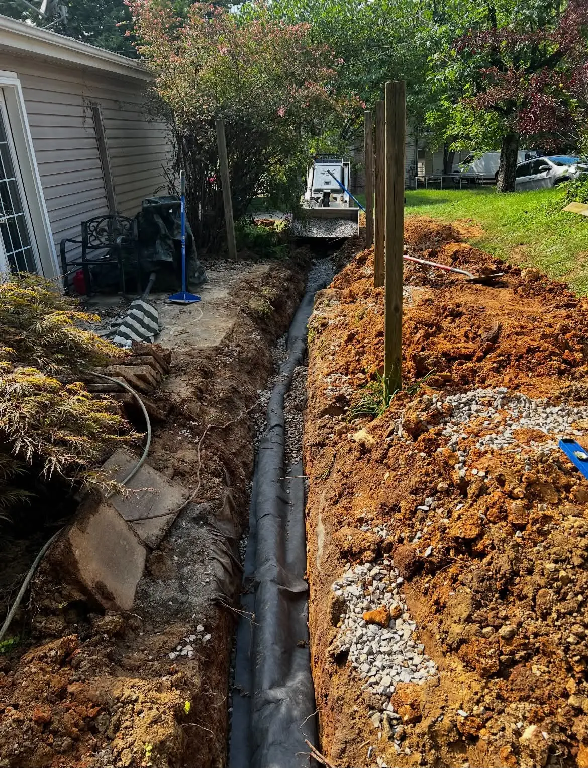Drainage line running along excavated trench with gravel bedding