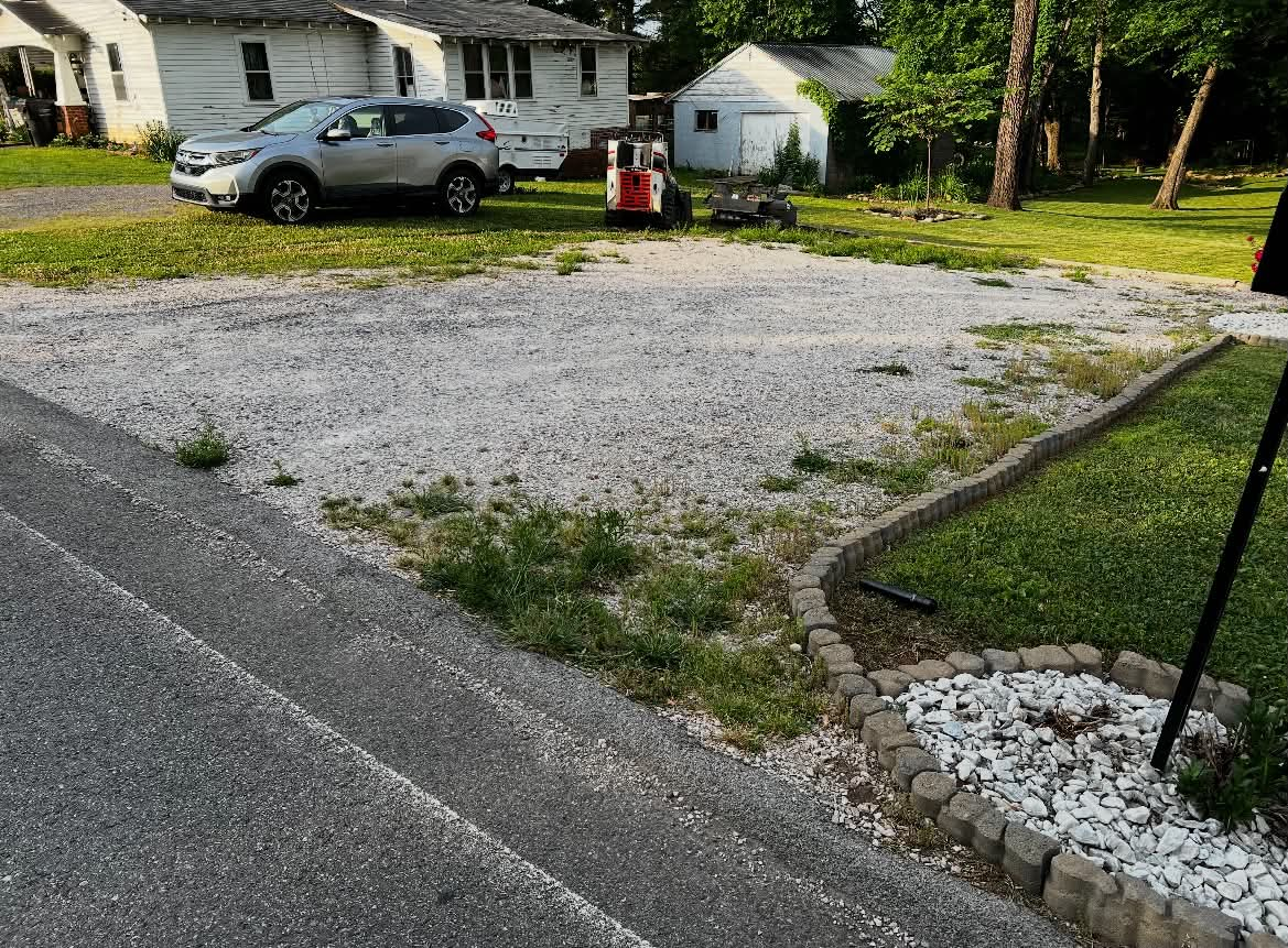 Worn gravel driveway with grass and thin coverage before repair
